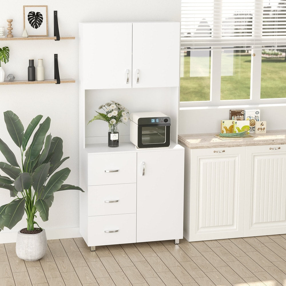 A white kitchen storage unit with items like a microwave and plant placed on and around it