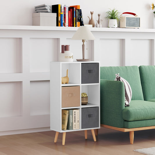 The storage cabinet placed in a living room next to a green sofa with decor on the shelves