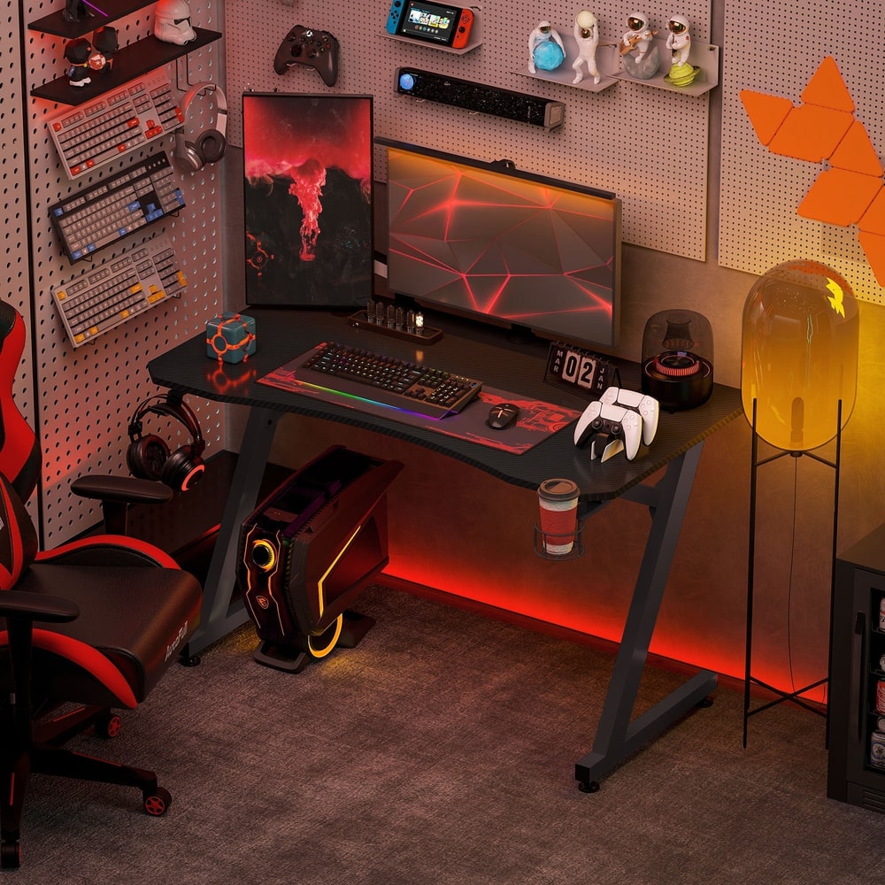 The gaming desk in a room with a gaming chair, computer and accessories
