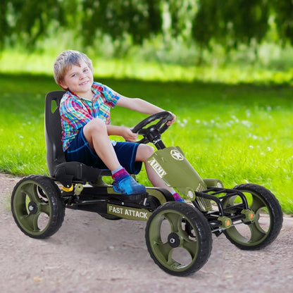 A happy young boy driving the green pedal go kart on a grassy lawn