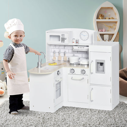 A young boy wearing a chef's hat and apron plays at the wooden toy kitchen