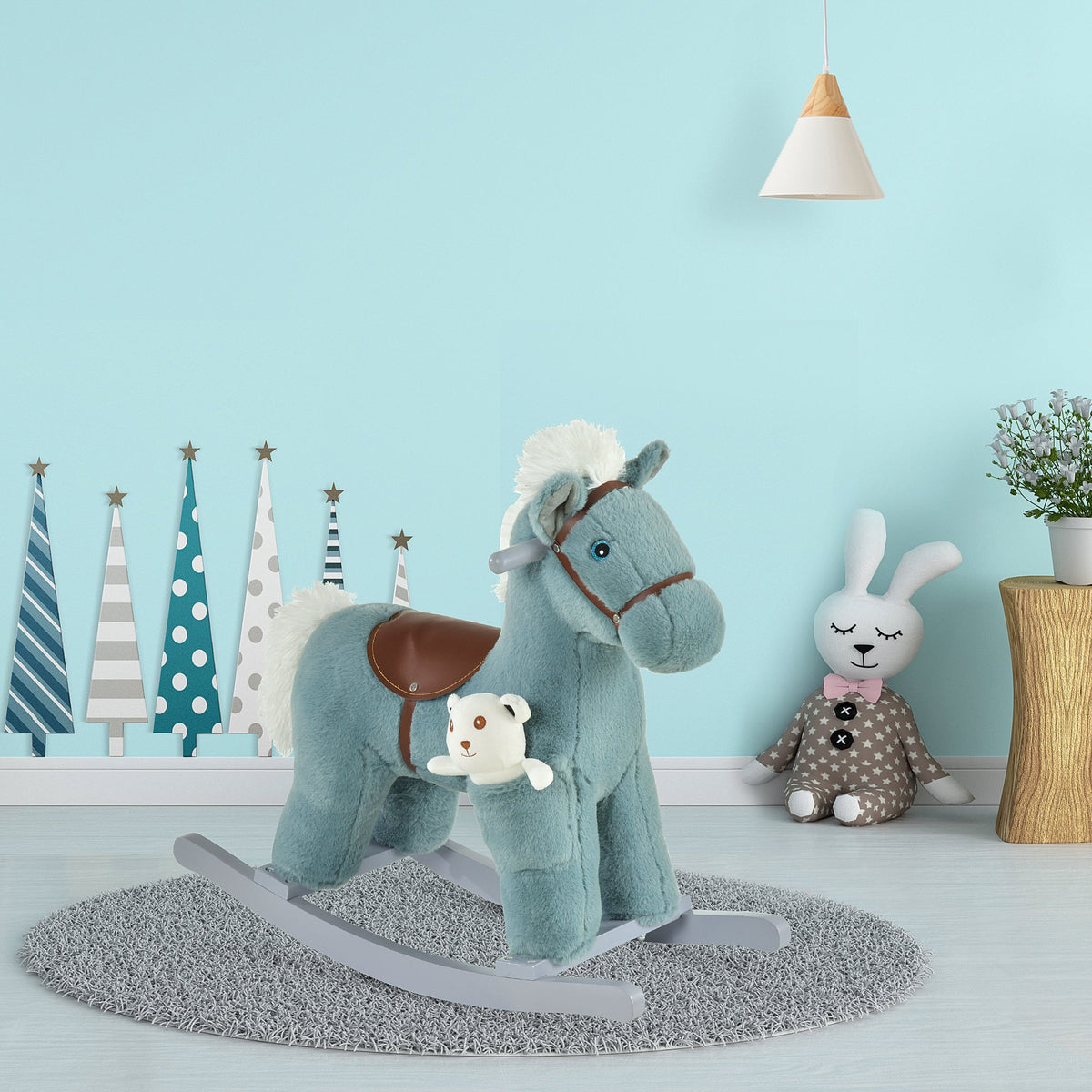 The blue plush rocking horse toy is in a child's nursery with a bunny toy