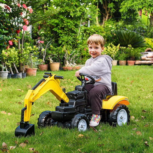 the ride-on car being used by a young child on a green lawn in a garden