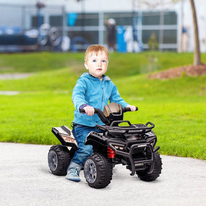 A young boy happily rides the black four-wheeler ATV car on a paved path