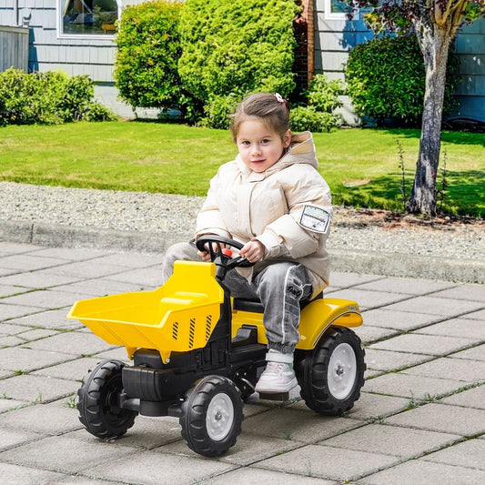 A young girl happily rides the yellow pedal tractor on a paved path