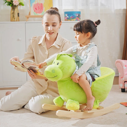 A young child sits on the plush dinosaur rocking horse while a woman reads a book