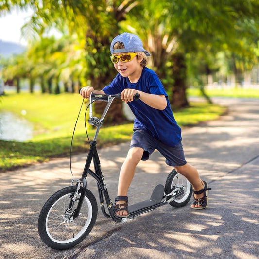The kids scooter being ridden by a young boy on a paved path in a park