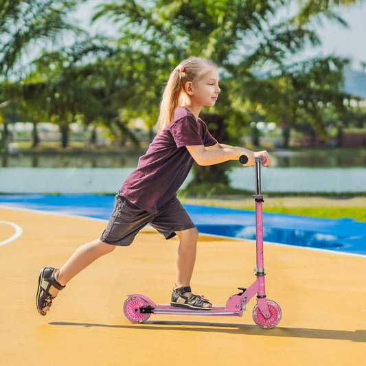 A young girl riding the pink kids scooter outdoors on a bright day