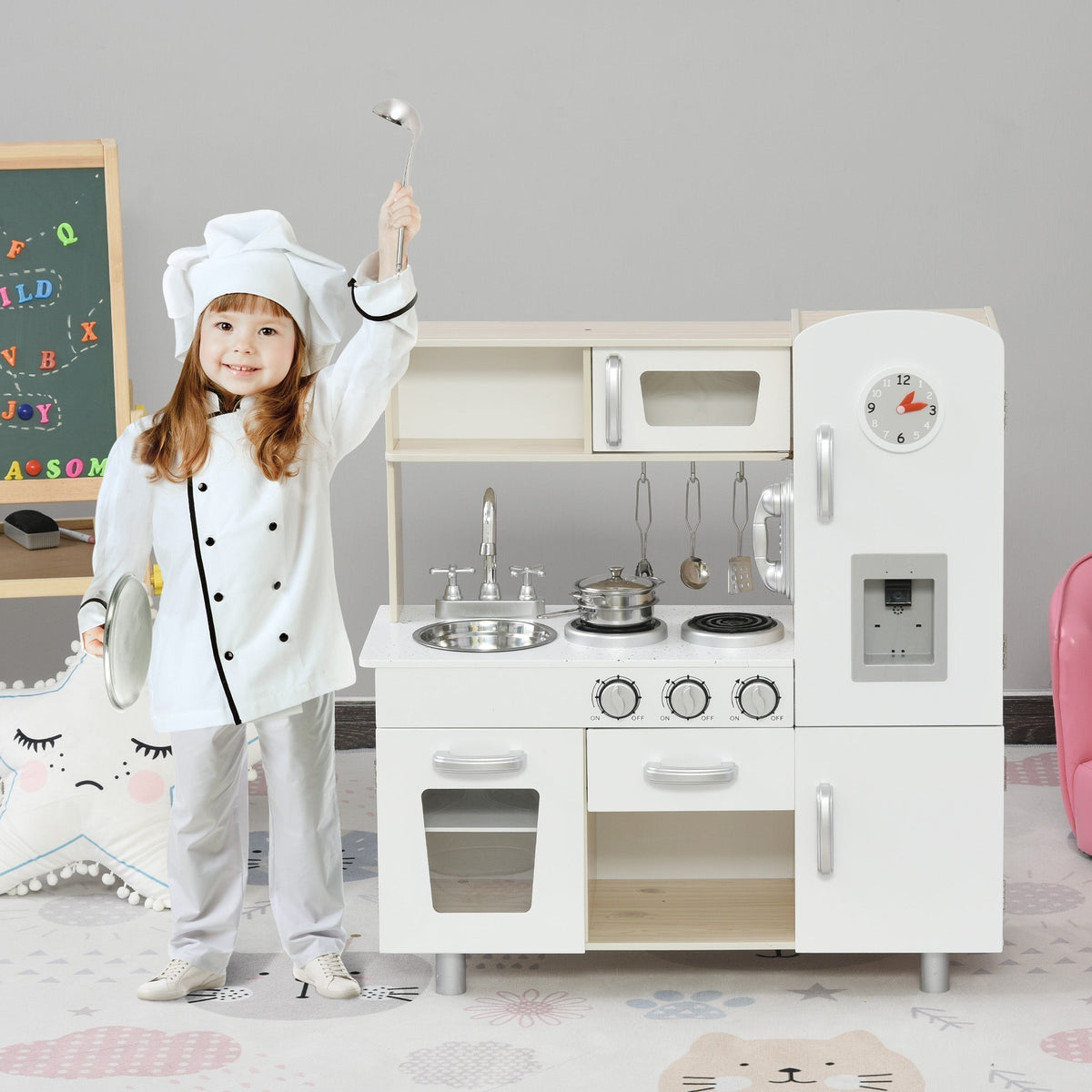 A young child dressed as a chef plays with the wooden toy kitchen