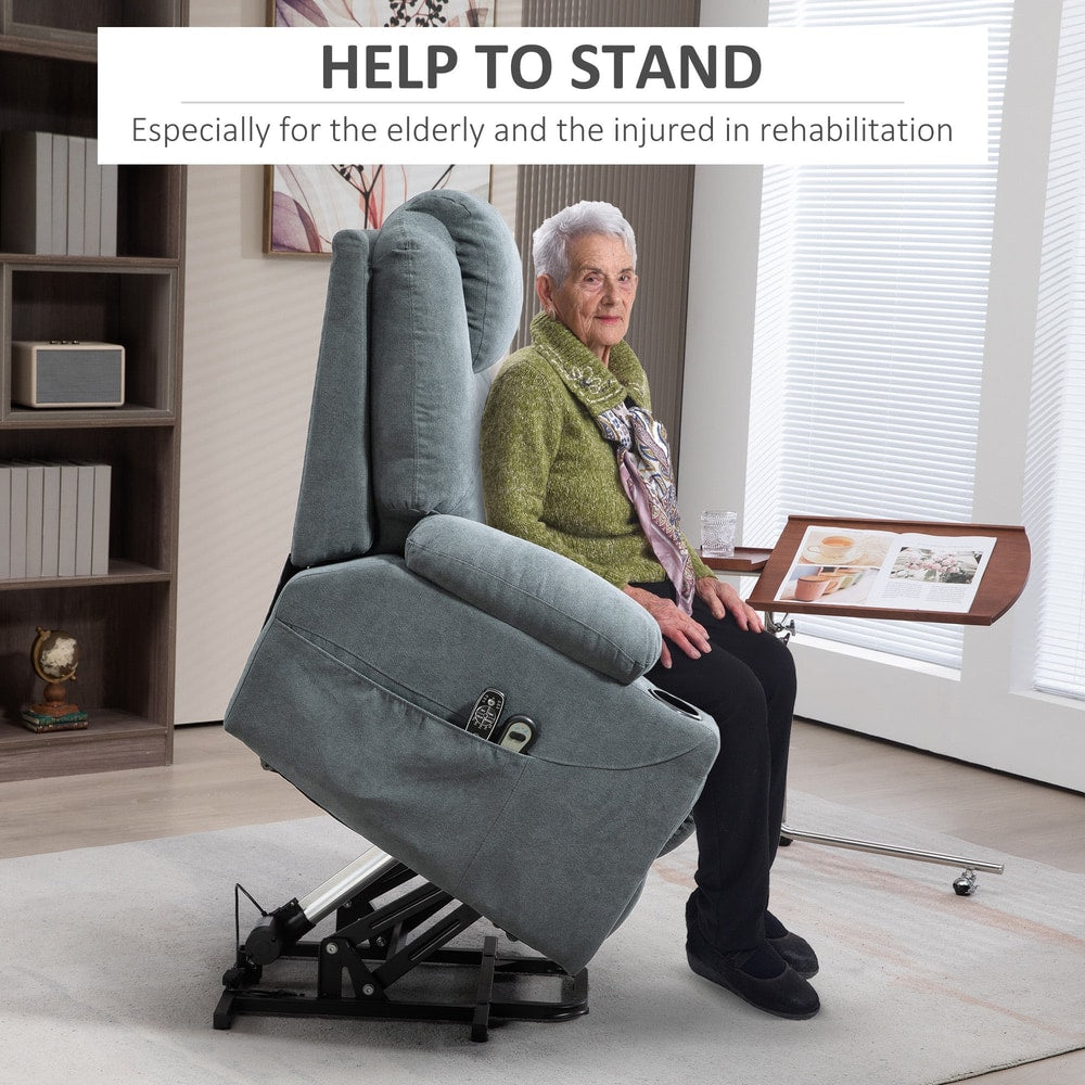 Elderly woman sitting in a grey fabric lift and recline armchair, demonstrating its ease of use