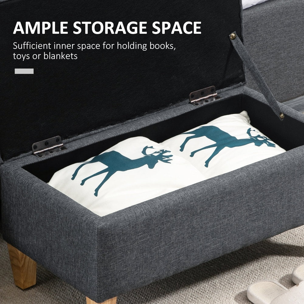 The dark grey storage ottoman is open showing ample storage space inside for books or blankets