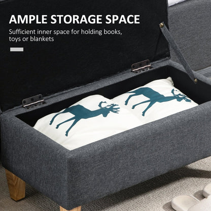 The dark grey storage ottoman is open showing ample storage space inside for books or blankets