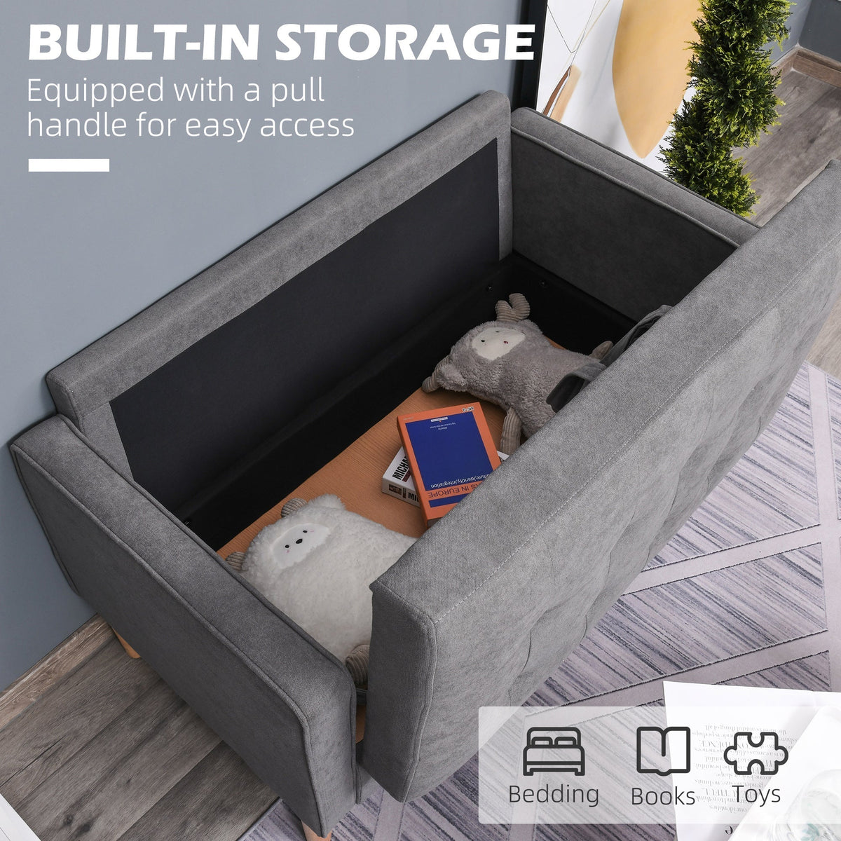 The grey two seater sofa with its storage compartment open, showing space for bedding and books
