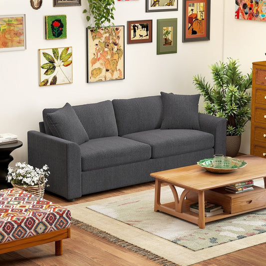 The grey jumbo cord three seater sofa is shown in a living room setting with a coffee table and rug