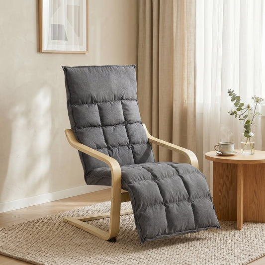 Grey armchair with footrest in a living room setting with a rug and side table