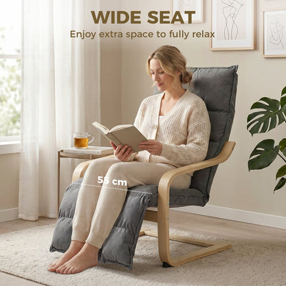 Woman reading a book on a grey armchair with footrest in a room