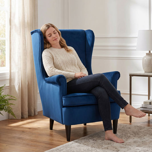 Woman relaxing in a blue velvet accent chair in a bright room
