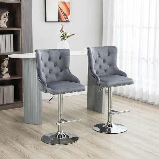Two grey velvet bar stools with button tufted backs in a modern kitchen setting