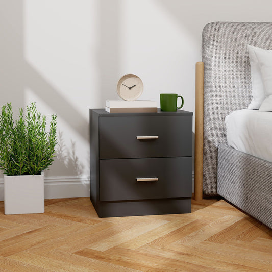 Black bedside cabinet with two drawers next to a bed in a bedroom setting