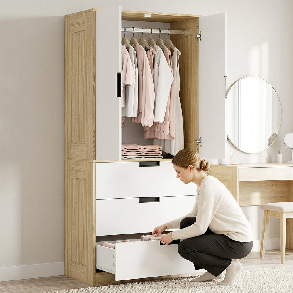 A woman using the oak and white wardrobe, opening a drawer to store clothes