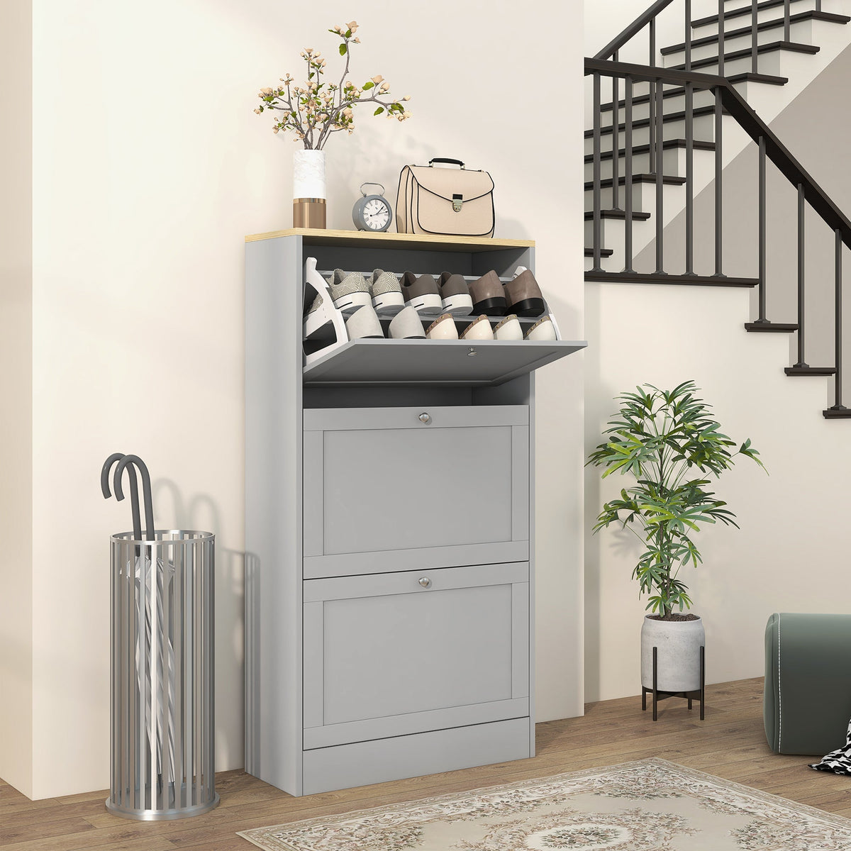 The shoe storage cabinet placed in a hallway with shoes inside the open top compartment