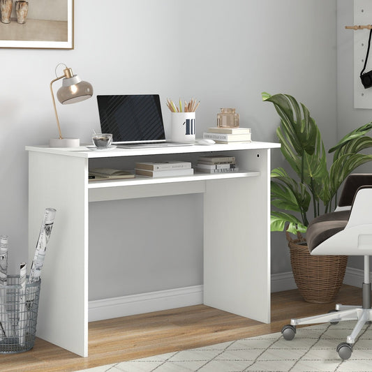 The office desk set up in a room with a laptop, lamp, and plant