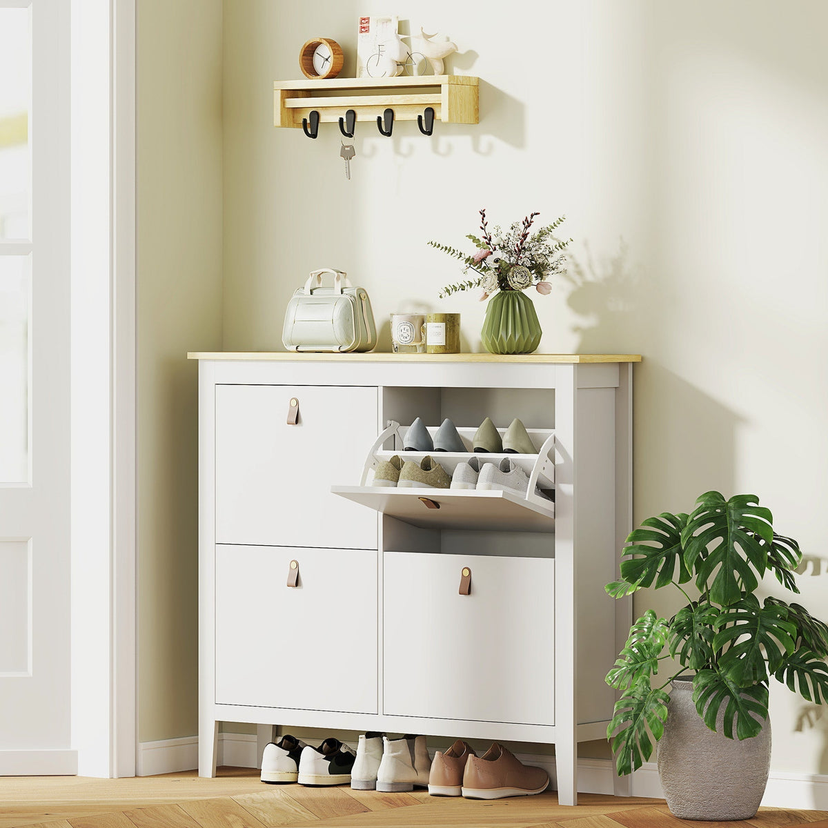 White shoe storage cabinet with a wood effect top in a hallway with shoes inside