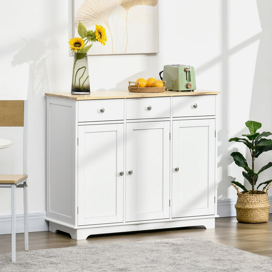 The white storage cabinet with rubber wood top shown in a dining room setting with a chair and plants