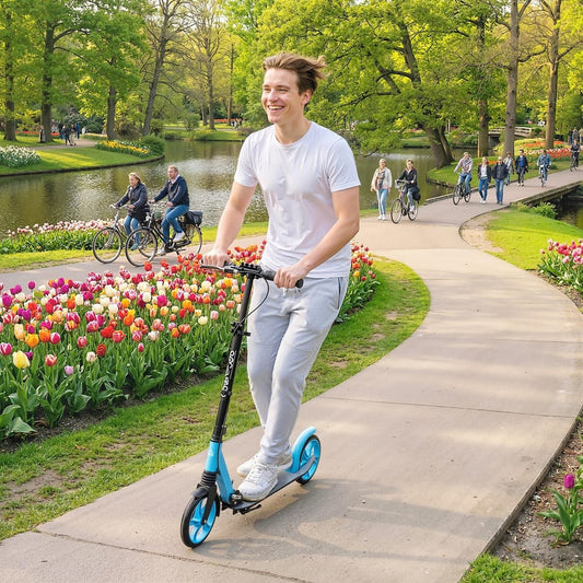 Man riding the blue kick scooter along a path with tulips and trees