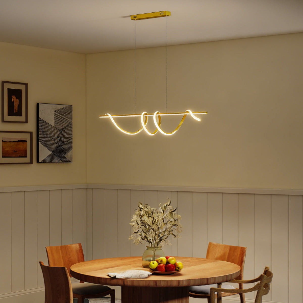 The gold tone ceiling light illuminating a dining room with four wooden chairs around a table