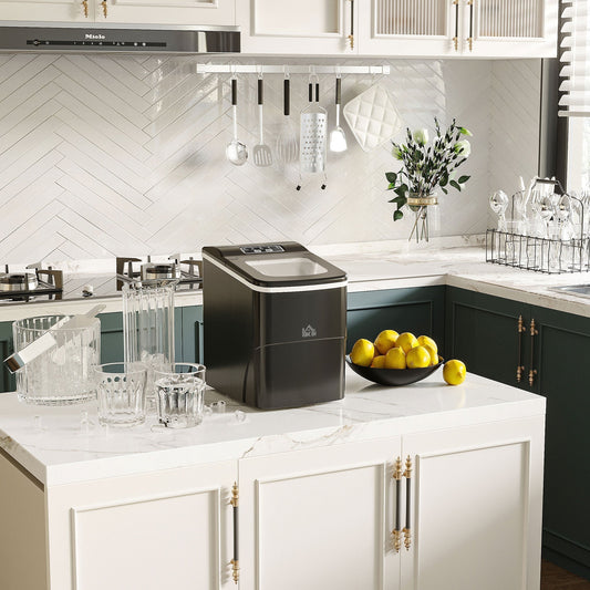 The ice cube machine sitting on a white kitchen counter next to a bowl of lemons and glassware