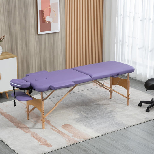 The purple portable massage bed set up in a room with a chair and cabinet nearby