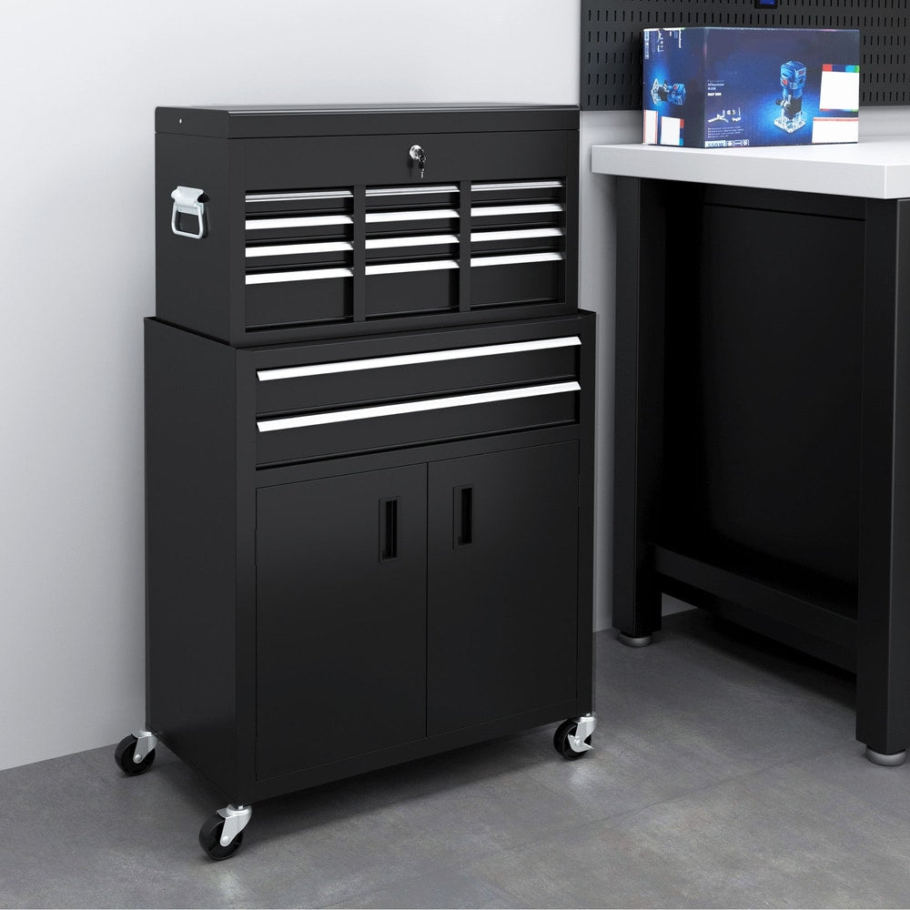 The black metal tool chest on wheels is shown in a workshop setting next to a workbench