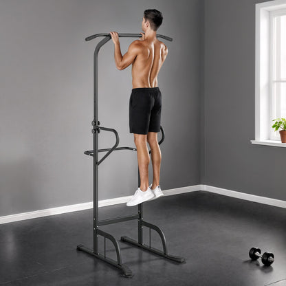 The power tower being used by a man to perform pull ups in a home gym setting