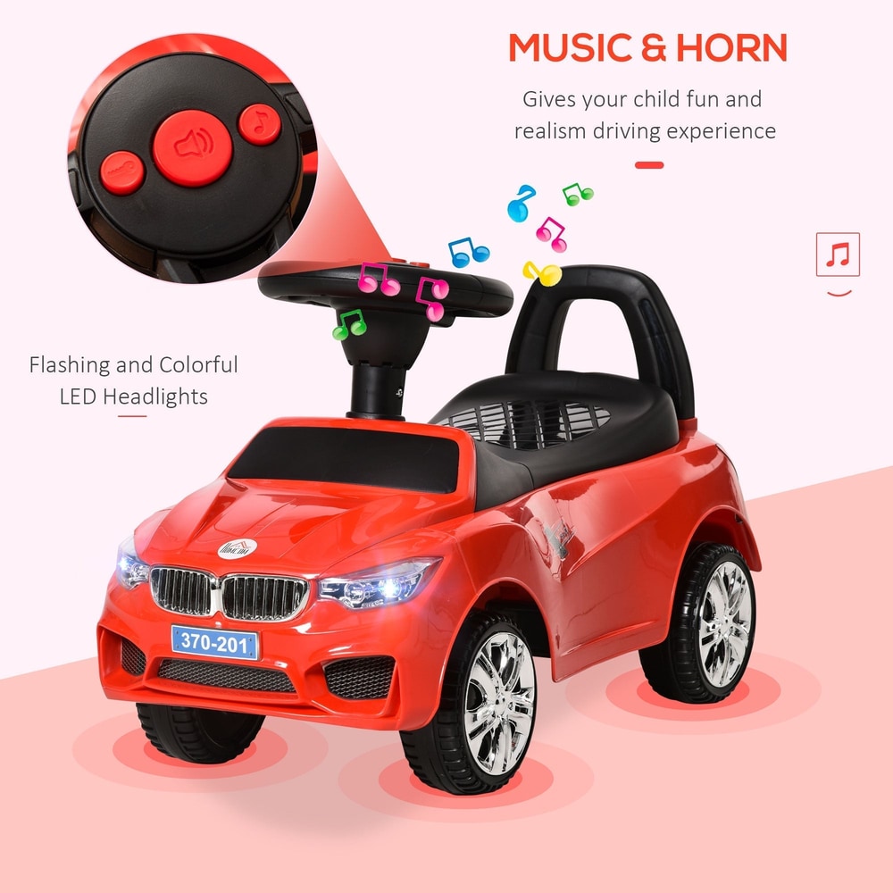 The red ride-on car has flashing LED headlights and music controls on the steering wheel