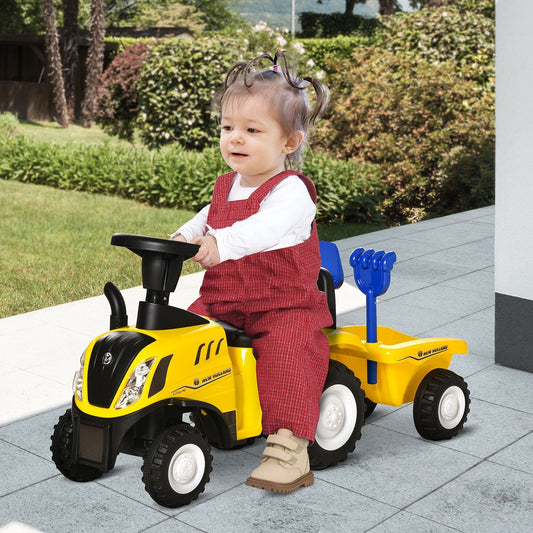 A baby sits on the yellow ride on tractor toy, playing outdoors