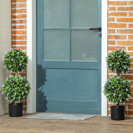 Two artificial ball trees with lavender flowers flanking a blue front door on a wooden porch
