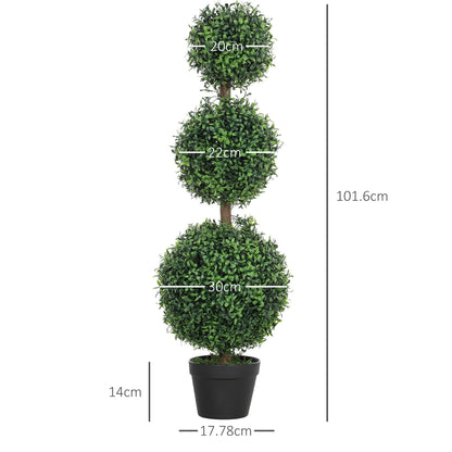 Two artificial boxwood trees in pots flanking a fireplace indoors