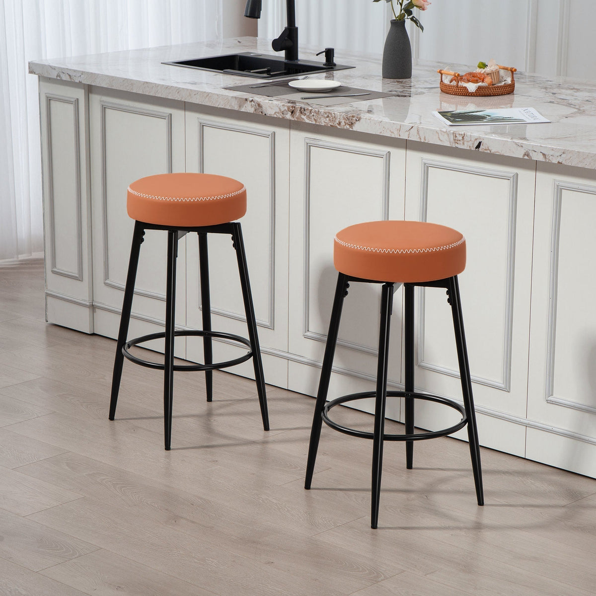 Two brown faux leather bar stools with black metal legs in a modern kitchen setting