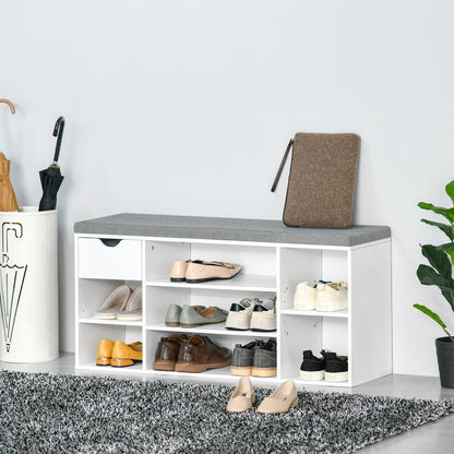 White shoe storage bench with cushion in a hallway with shoes and umbrellas