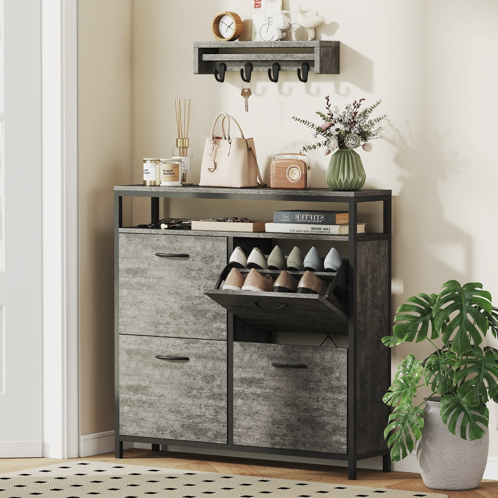 The shoe storage cabinet in a hallway with items on top and shoes inside the flip drawers
