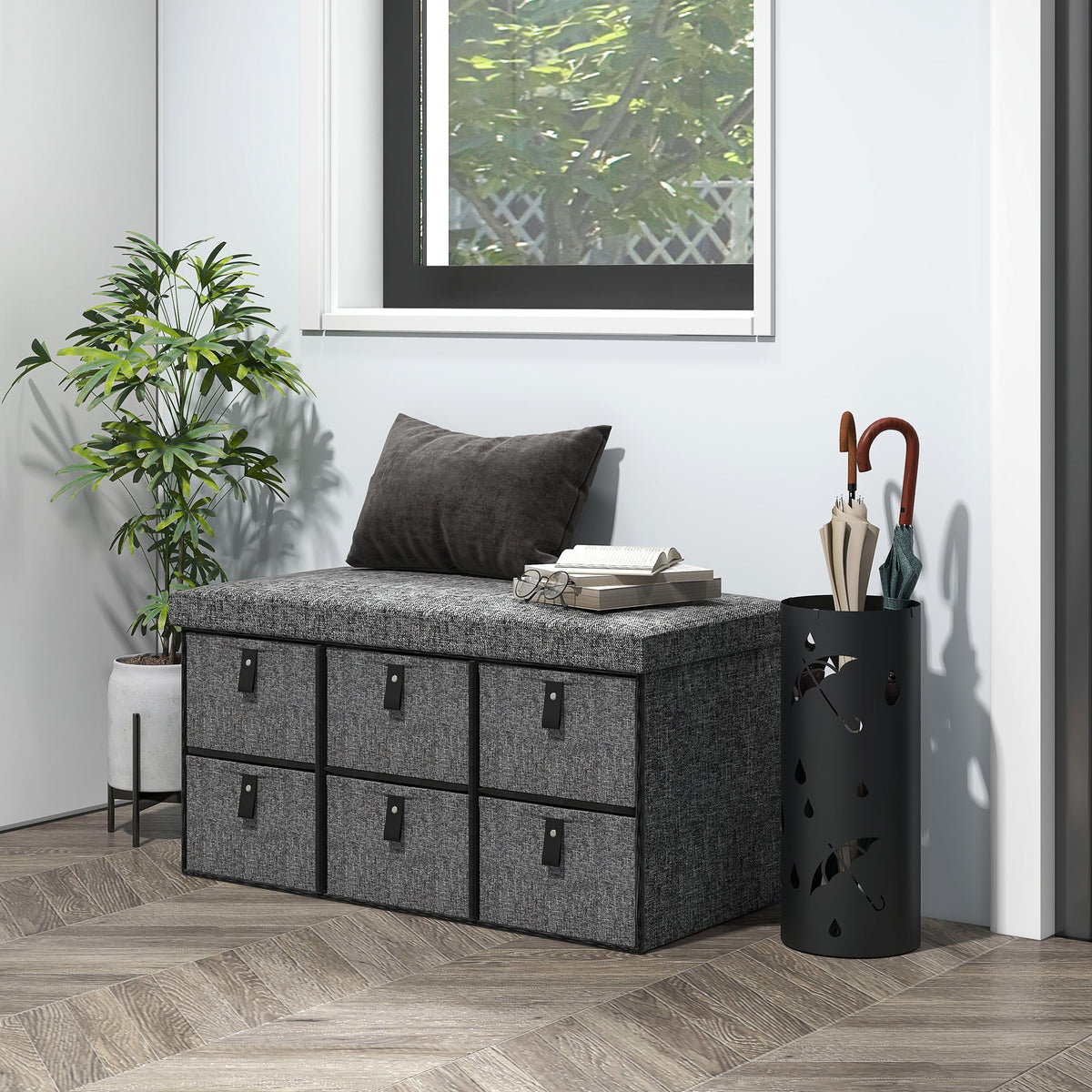 The shoe storage bench is shown in a hallway with a plant and umbrella stand