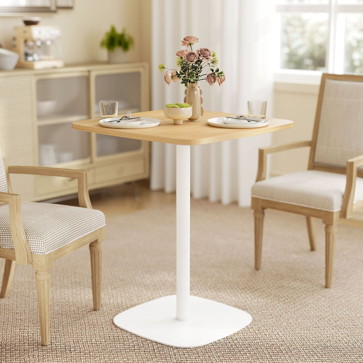 Small dining table with two chairs and a vase of flowers in a dining room setting