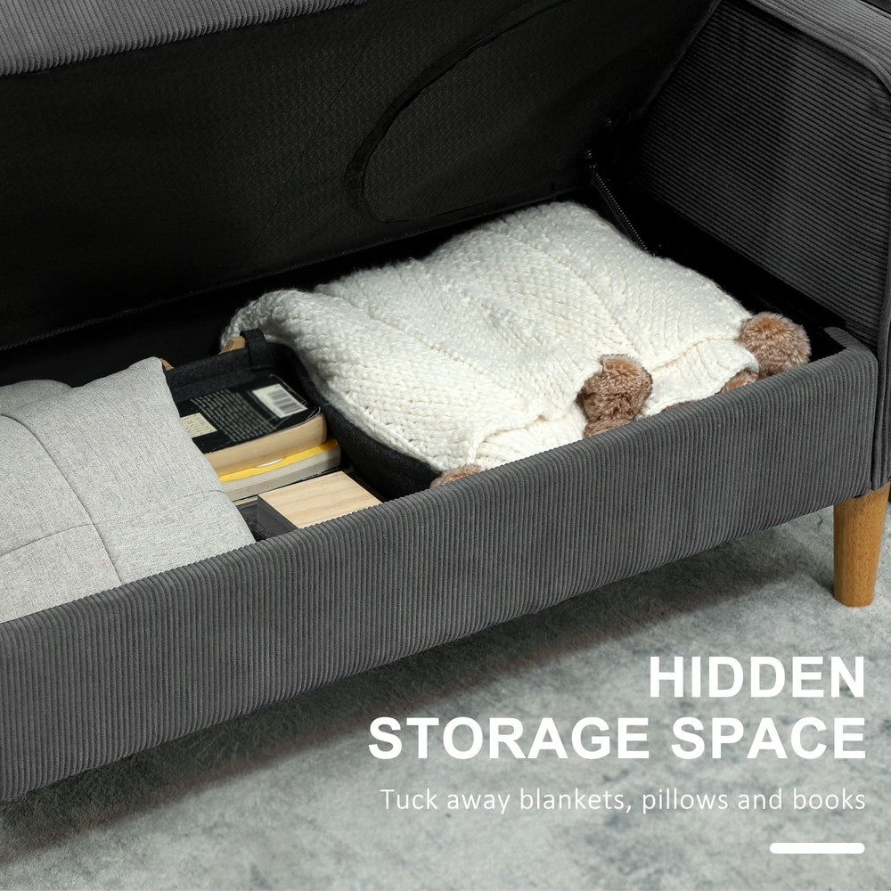 The grey corduroy sofa with its seat lifted to reveal hidden storage space for blankets and books