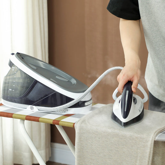 The steam generator iron in use, with a hand holding the iron unit and pressing it onto a garment on an ironing board