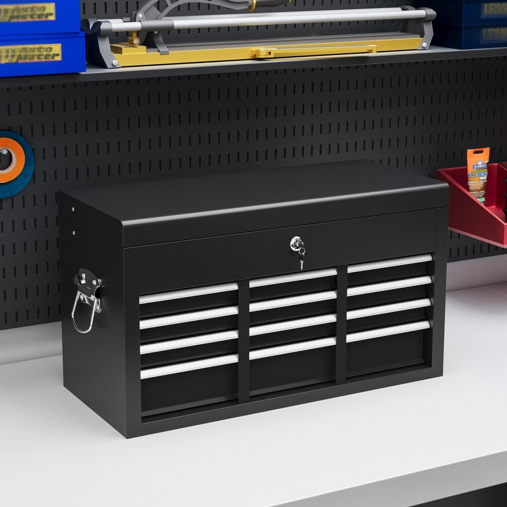 The black tool box sitting on a workshop bench against a pegboard wall