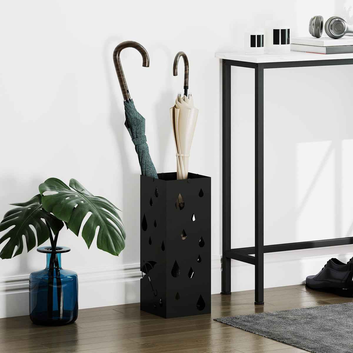 The steel umbrella stand holding two umbrellas in a hallway setting