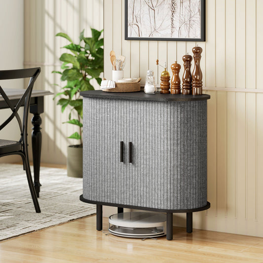 Grey storage cabinet with fluted doors in a dining room setting next to a chair and plant