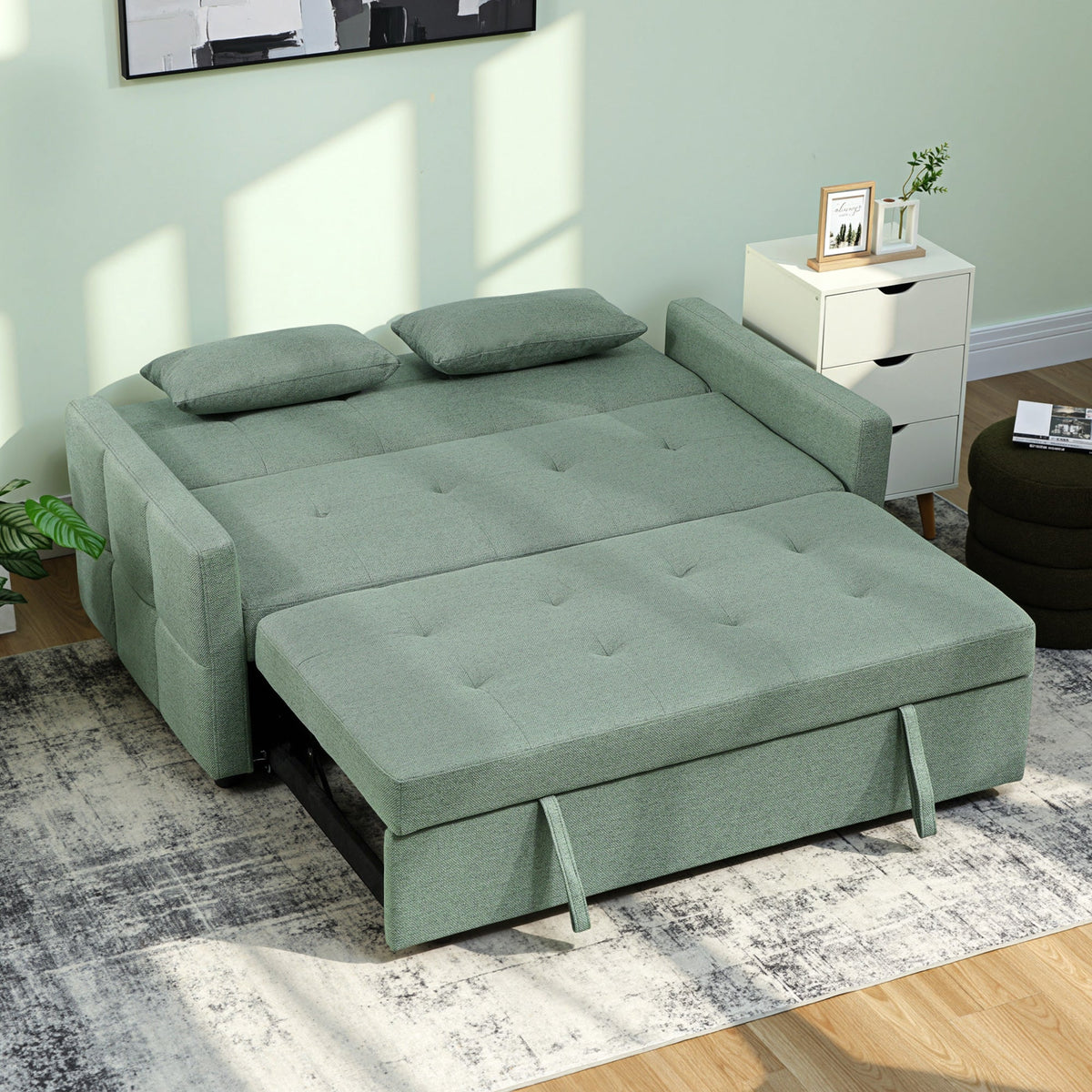 The green sofa bed pulled out into a bed with two pillows