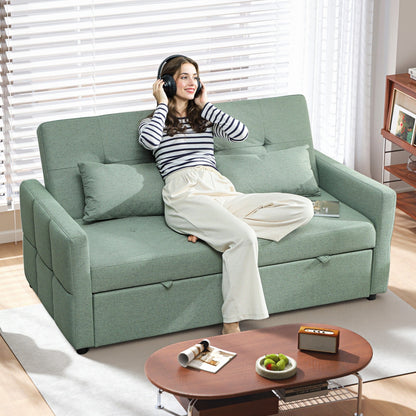 A woman wearing headphones sits on the green sofa bed in a living room
